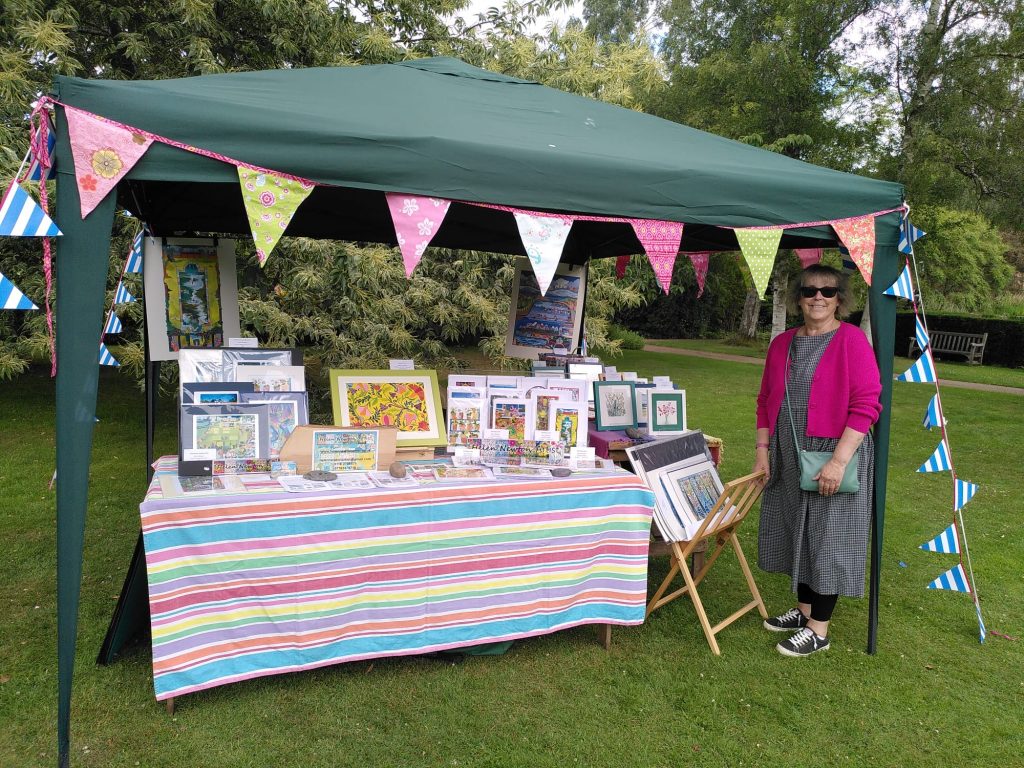 Photo of Hel standing next to her outdoor stall at the Botanic Garden Open Day