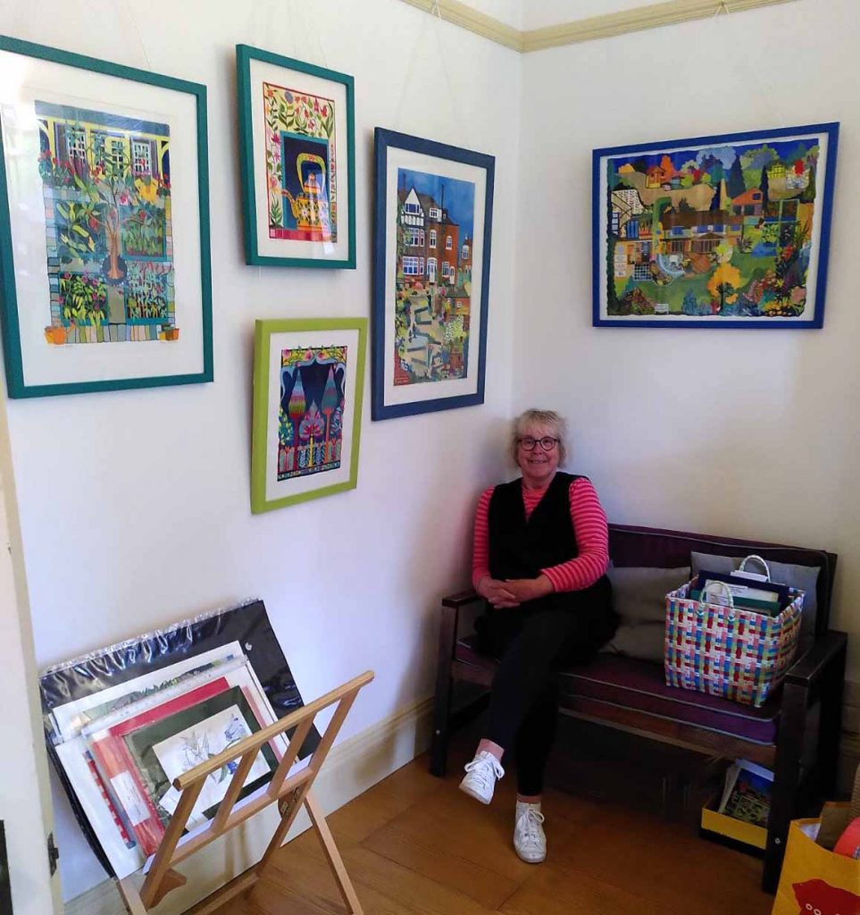 Photo of Helen surrounded by her paintings at Art House 2025